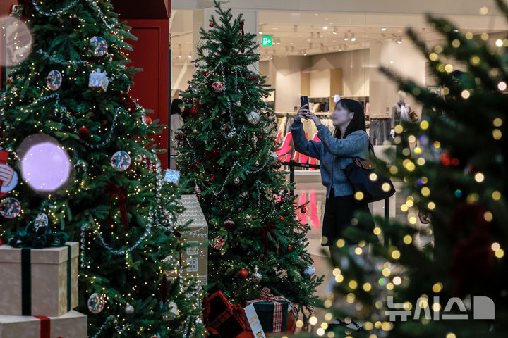 [서울=뉴시스] 정병혁 기자 = 2일 서울 영등포구 타임스퀘어에 설치된 대형 크리스마스 트리를 찾은 시민들이 사진을 찍으며 즐거운 시간을 보내고 있다.&nbsp; 복합쇼핑몰 경방 타임스퀘어는 올해 'Merry & Bright'를 테마로 자체 캐릭터 '탐스프렌즈'와 협업해 꾸며진 13m의 초대형 크리스마스 트리를 공개했다. 2025.11.02. jhope@newsis.com