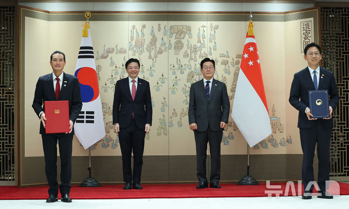 [서울=뉴시스] 고범준 기자 = 배경훈 과학기술정보통신부 장관과 탄 키앗 하우 싱가포르 보건·디지털개발정보 선임국무장관이 2일 서울 용산 대통령실 청사에서 이재명 대통령과 로렌스 웡 싱가포르 총리가 참석한 가운데 '디지털 협력에 관한 양해각서'를 교환하고 기념촬을 하고 있다. (대통령실통신사진기자단) 2025.11.02. bjko@newsis.com