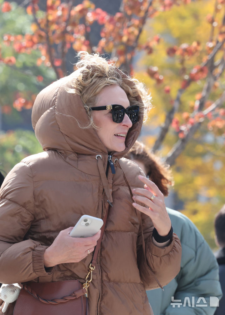 [서울=뉴시스] 김명원 기자 =지난 2일 서울 종로구 광화문 광장에서 시민과 관광객들이 옷을 여미며 이동하고 있다. 2025.11.02. kmx1105@newsis.com