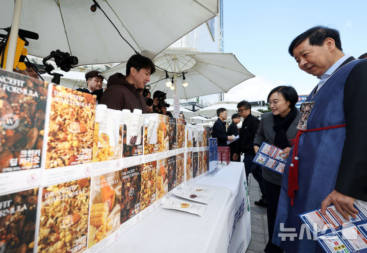 [서울=뉴시스] 홍효식 기자 = 2일 서울 중구 두타몰 광장에서 코리아 그랜드 페스티벌의 일환으로 열린 소상공인 우수제품 판매전 '모두의 동행' 행사에서 구윤철 기획재정부 장관과 한성숙 중소벤처기업부 장관이 식사대용 및 영양보충 쉐이크를 살펴보고 있다. 2025.11.02. yesphoto@newsis.com