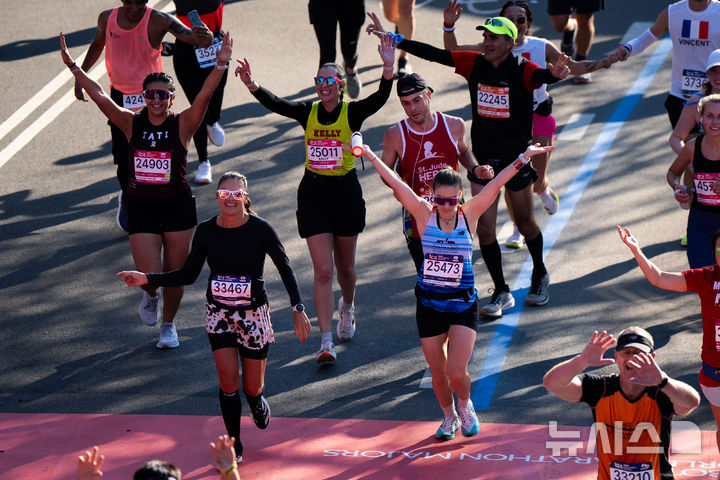 [뉴욕=AP/뉴시스] 2일(현지 시간) 미국 뉴욕에서 열린 2025 뉴욕 마라톤 대회에서 참가자들이 결승선을 통과하고 있다. 2025.11.03.