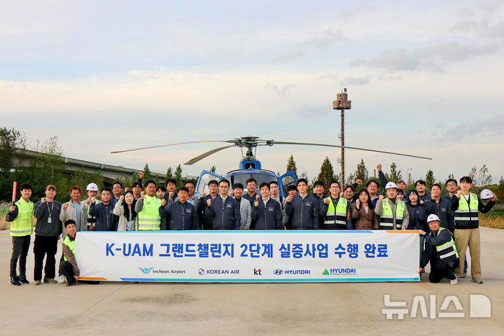 [서울=뉴시스]KT는 국토교통부가 주관하는 한국형 도심항공교통 그랜드챌린지 2단계 실증을 성공적으로 마무리했다고 3일 밝혔다. 사진은KT를 비롯한 현대자동차, 현대건설, 인천국제공항공사, 대한항공이 함께하는 K-UAM 원팀이 인천 아라뱃길 실증 현장에서 기념사진을 촬영하는 모습. (사진=KT 제공)