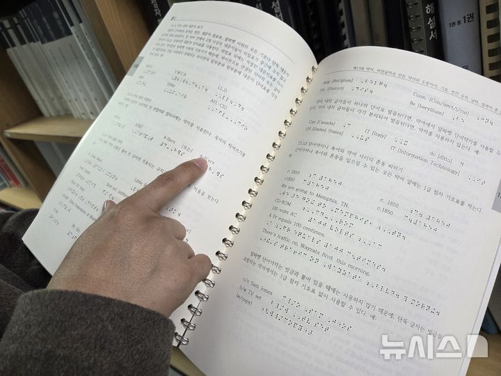 [서울=뉴시스] 김윤영 수습기자 = 이길원 실로암시각장애인복지관 점역팀장이 영어 점자 해설서를 보여주며 규정을 설명하고 있다. 2025.10.28 youn@newsis.com *재판매 및 DB 금지