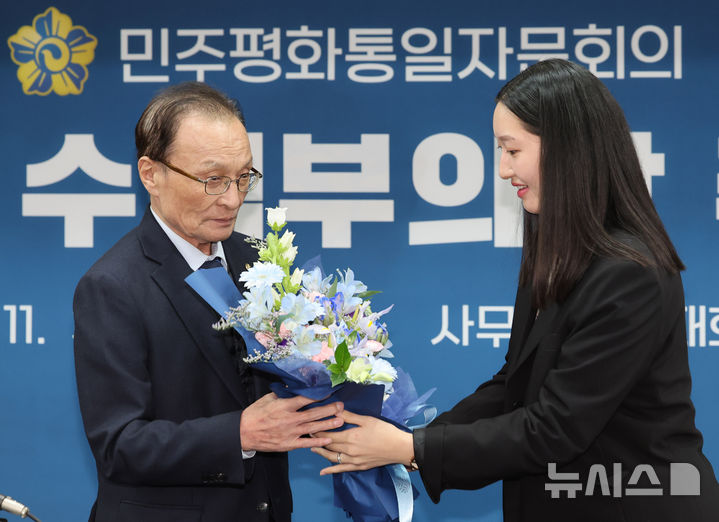 [서울=뉴시스] 배훈식 기자 = 이해찬(왼쪽) 민주평화통일자문회의 수석부의장이 3일 오전 서울 중구 민주평통사무처에서 열린 취임식에서 꽃다발을 받고 있다. 2025.11.03. dahora83@newsis.com