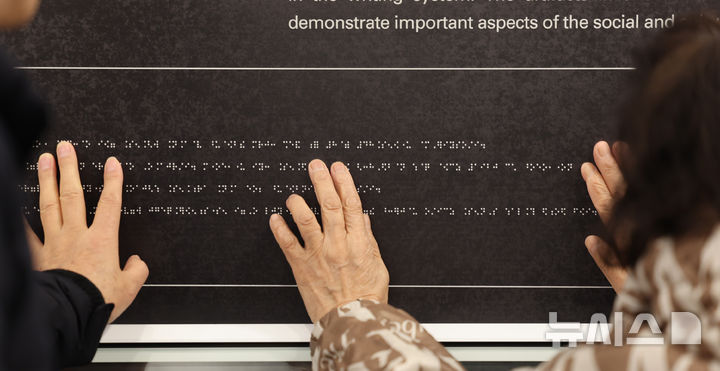 [인천=뉴시스] 전진환 기자 = 점자의 날을 하루 앞둔 3일 오후 인천 미추홀구 송암점자도서관 송암 박두식 기념관에서 시각 장애인들이 한글 점자 훈맹정음의 유래와 역사적 가치를 설명한 점자 안내문을 읽고 있다.&nbsp; 점자의 날은 시각장애인의 세종대왕이라 불리는 송암 박두성 선생이 시각장애인을 위해 한글 점자를 만들어 반포한 1926년 11월 4일을 기념하는 날이다. 2025.11.03. amin2@newsis.com