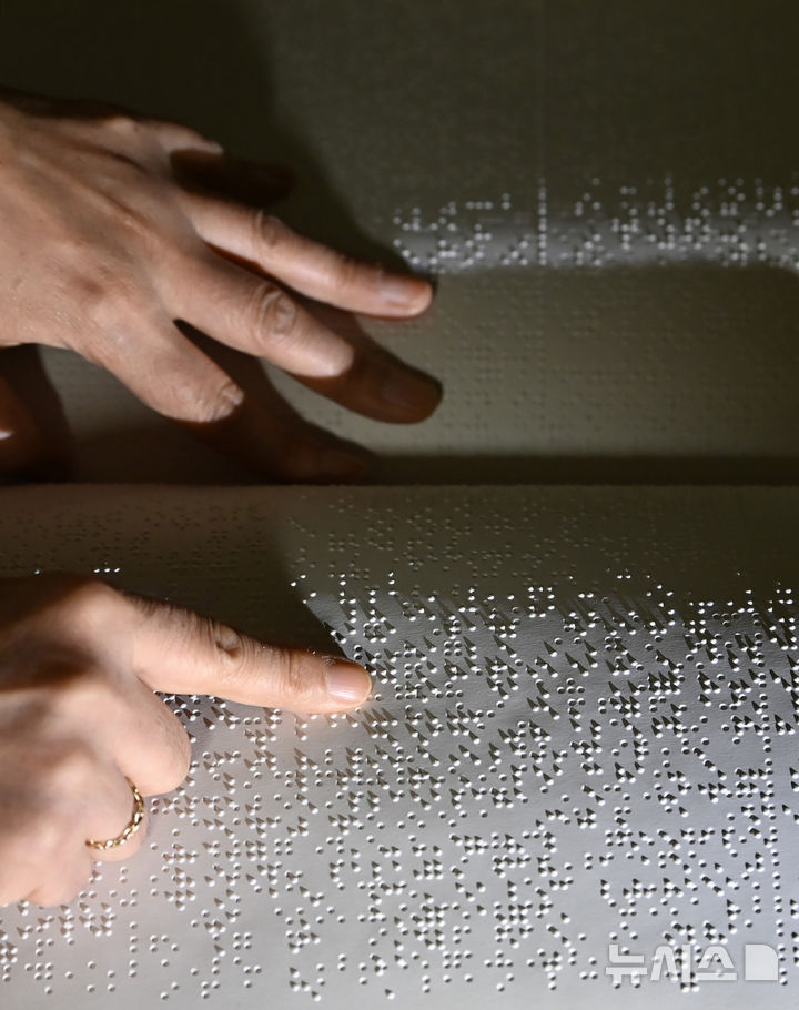 [수원=뉴시스] 김종택 기자 = '한글 점자의 날'을 하루 앞둔 3일 경기 수원시 영통구 장애인종합복지관 사랑샘도서관에서 관계자가 점자책을 읽고 있다. 2025.11.03. jtk@newsis.com