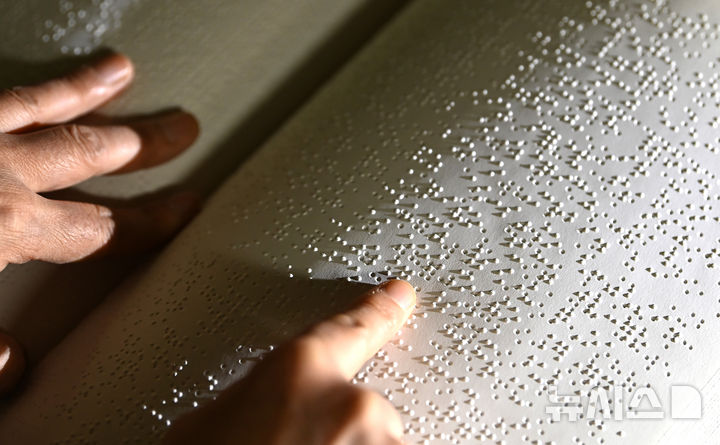 [수원=뉴시스] 김종택 기자 = '한글 점자의 날'을 하루 앞둔 3일 경기 수원시 영통구 장애인종합복지관 사랑샘도서관에서 관계자가 점자책을 읽고 있다. 2025.11.03. jtk@newsis.com