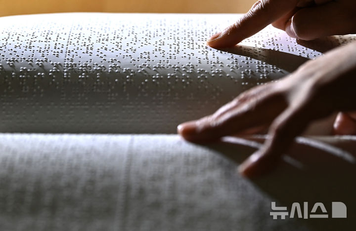 [수원=뉴시스] 김종택 기자 = '한글 점자의 날'을 하루 앞둔 3일 경기 수원시 영통구 장애인종합복지관 사랑샘도서관에서 관계자가 점자책을 읽고 있다. 2025.11.03. jtk@newsis.com
