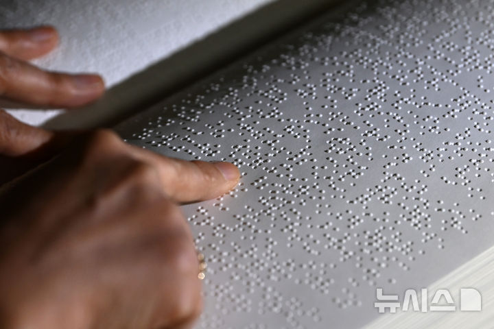 [수원=뉴시스] 김종택 기자 = '한글 점자의 날'을 하루 앞둔 3일 경기 수원시 영통구 장애인종합복지관 사랑샘도서관에서 관계자가 점자책을 읽고 있다. 2025.11.03. jtk@newsis.com