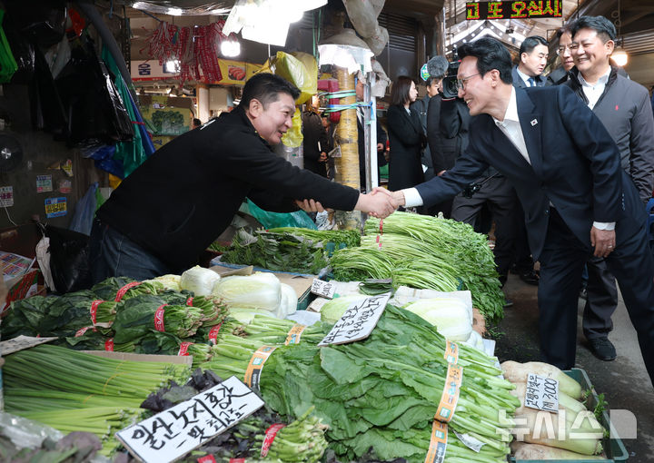 [서울=뉴시스] 박주성 기자 = 김민석 국무총리가 3일 김장 물가 점검차 서울 동대문구 경동시장을 방문해 상인과 인사를 나누고 있다. (공동취재). 2025.11.03. photo@newsis.com