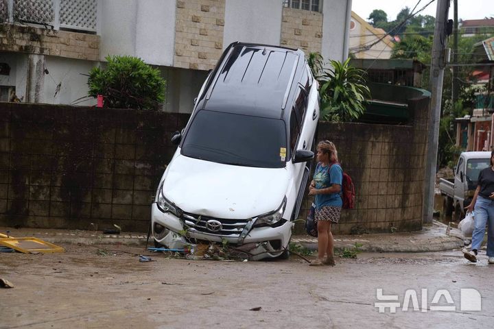 [세부=AP/뉴시스] 필리핀 중부 세부에서 태풍 갈매기가 지나면서 불어난 홍수에 떠내려온 자동차가 4일 담장에 걸려 있다. 2025.11.04.