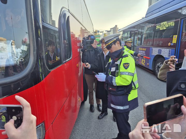 [서울=뉴시스] 이윤석 수습기자=4일 오전 서울 종로구 경복궁사거리 인근. 경찰이 꼬리물기한 버스를 단속해 흰색 빗금 안전지대에 세워 범칙금을 부과하고 있다. 2025.11.04. leeys@newsis.com