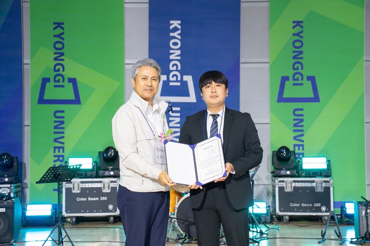 [수원=뉴시스] 김건우 학생(오른쪽)이 원용석 총동문회장과 장학증서 수여 후 기념촬영을 하고 있다. (사진=경기대 제공) 2025.11.04. photo@newsis.com *재판매 및 DB 금지