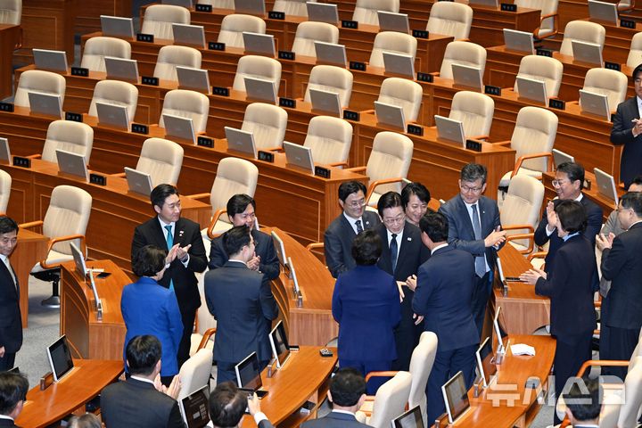 [서울=뉴시스] 국회사진기자단 = 이재명 대통령이 4일 서울 여의도 국회 본회의장에서 2026년도 예산안 및 기금운용계획안에 대한 시정연설에 참석하며 여당 의원들과 악수하고 있다. 이 대통령 시정연설하는 동안 국민의힘 의원들이 불참하면서 뒤편 의석이 비어 있다. 2025.11.04. photo@newsis.com