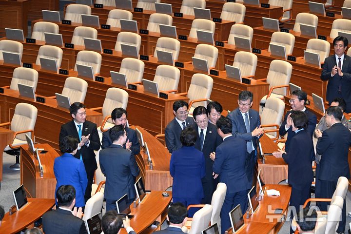 [서울=뉴시스] 국회사진기자단 = 이재명 대통령이 4일 서울 여의도 국회 본회의장에서 2026년도 예산안 및 기금운용계획안에 대한 시정연설에 참석하며 여당 의원들과 악수하고 있다.  이 대통령 시정연설하는 동안 국민의힘 의원들이 불참하면서  뒤편 의석이 비어 있다. 2025.11.04. photo@newsis.com