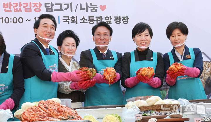 [서울=뉴시스] 김금보 기자 = 김민석 국무총리와 박수현 더불어민주당 의원 등 참석자들이 4일 서울 여의도 국회 소통관 앞 광장에서 열린 사랑의 반값김장 담그기 나눔 행사에서 김치 속을 넣고 기념촬영을 하고 있다. 2025.11.04. kgb@newsis.com