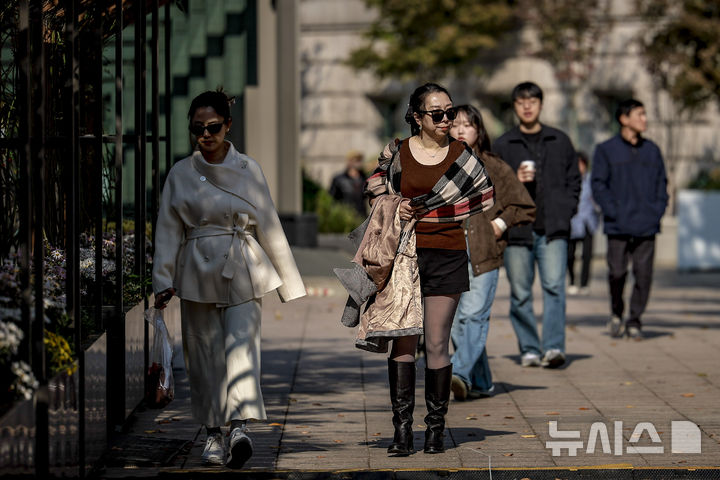 [서울=뉴시스] 정병혁 기자 = 완연한 가을 날씨를 보인 4일 서울 중구 서울시청 인근에서 겉옷을 벗은 여행객이 이동하고 있다. 2025.11.04. jhope@newsis.com