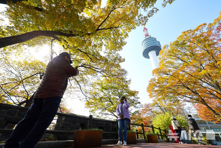 [서울=뉴시스] 황준선 기자 = 완연한 가을 날씨를 보인 4일 서울 중구 남산을 찾은 시민들이 단풍길을 걷고 있다. 2025.11.04. hwang@newsis.com