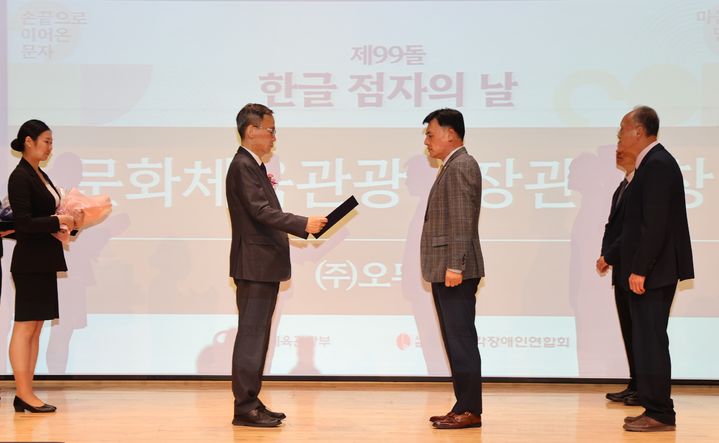 [서울=뉴시스] 지난 4일 열린 '제99돌 한글 점자의 날 기념식'에서 문화체육관광부 김영수 차관(왼쪽에서 두 번째)이 황성만 오뚜기 대표이사에게 문체부 장관 표창을 수여하고 있다.(사진=오뚜기 제공) *재판매 및 DB 금지