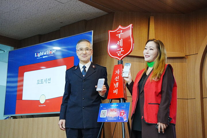 [서울=뉴시스] 4일 서울 서대문구 구세군빌딩에서 열린 'NFC 모금 도입 기념행사'에서 NFC 태그로 기부행한 스마트폰 화면을 보여주는 김병윤(왼쪽) 구세군 한국군국 사령관과 이사벨 홍보대사 (사진=구세군 제공) 2025.10.05. photo@newsis.com *재판매 및 DB 금지