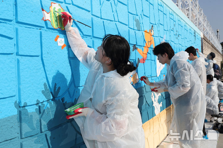[세종=뉴시스]한국석유공사는 5일 대한적십자사와 함께 울산 강양항 인근 어촌마을에서 '어촌에 희망을 입히는 벽화 그리기' 봉사활동을 진행했다.(사진=석유공사 제공)