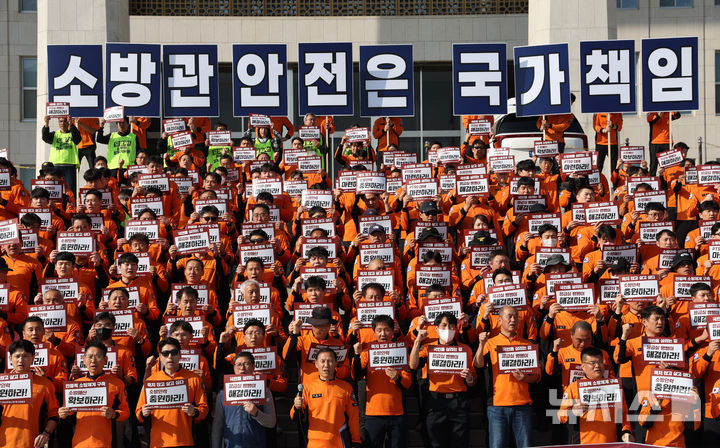 [서울=뉴시스] 김명년 기자 = 전국공무원노동조합 소방본부 조합원들이 지난 5일 오후 서울 여의도 국회 본청 앞 계단에서 제63주년 소방의날 기자회견을 열고 구호를 외치고 있다. 2025.11.05. kmn@newsis.com