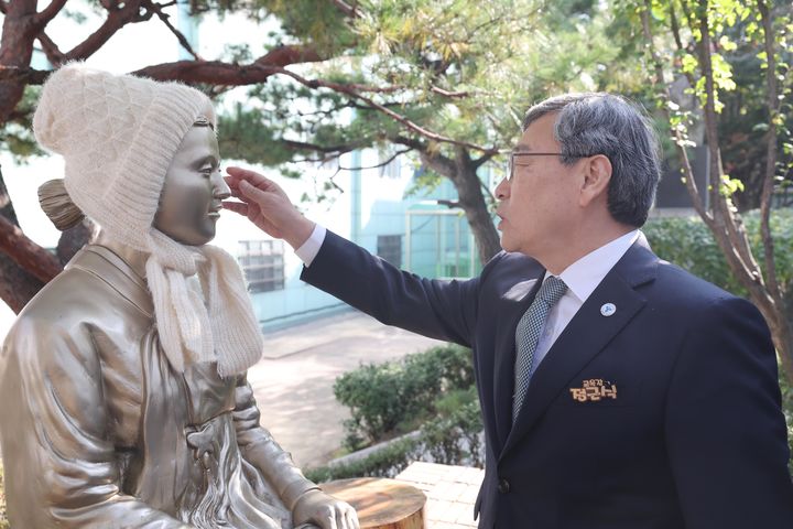 [서울=뉴시스] 정근식 서울시교육감이 지난해 11월 5일 오후 우익단체가 평화의 소녀상 철거 집회를 예고한 서울의 한 고등학교를 찾아 평화의 소녀상에 털모자를 씌워주고 있다. (사진=서울시교육청 제공) 2025.11.05. photo@newsis.com *재판매 및 DB 금지