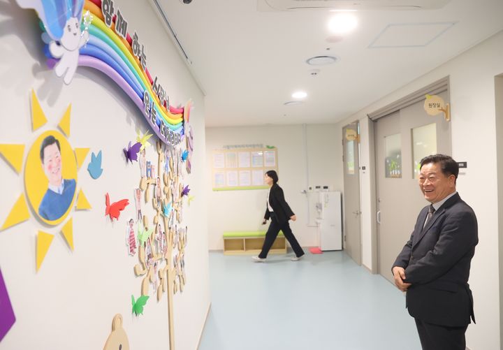 [광명=뉴시스]박승원 광명시장이 6일 어린이집 벽에 붙어있는 자신의 얼굴을 보고 웃고 있다.(사진=광명시 제공)2025.11.06.photo@newsis.com *재판매 및 DB 금지