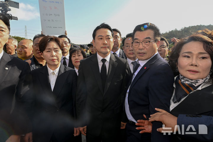 [광주=뉴시스] 이영주 기자 = 장동혁(가운데) 국민의힘 당대표와 양향자(왼쪽) 최고위원이 6일 오후 광주 북구 운정동 국립5·18민주묘지에서 광주시민들에 의해 참배가 가로막히자 난처해하고 있다. 2025.11.06. leeyj2578@newsis.com