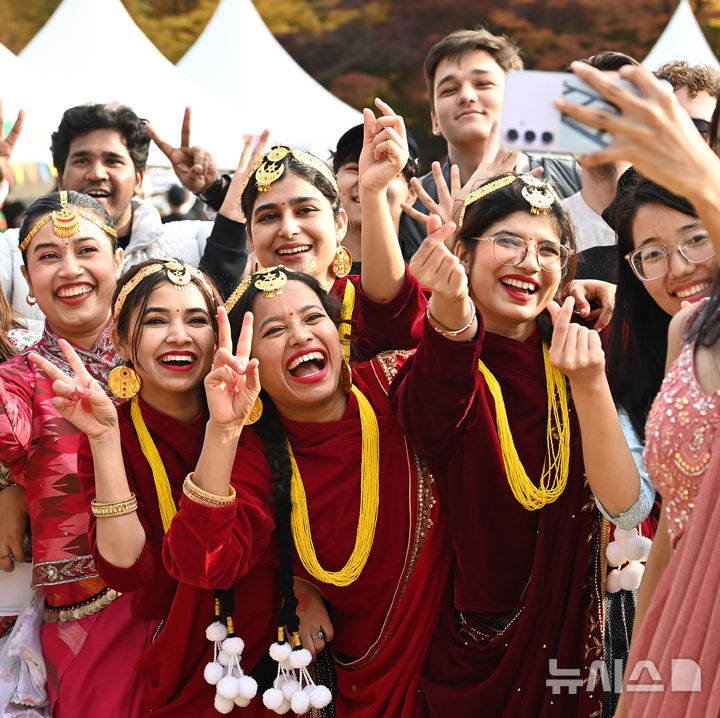 [수원=뉴시스] 김종택 기자 = 6일 경기 수원시 아주대학교에서 열린 ‘아주 인터내셔널 데이’에서 외국인 유학생들이 전통의상을 입고 기념촬영을 하고 있다.아주 인터내셔널 데이는 외국인 유학생들이 각 나라의 춤과 노래, 놀이, 음식 등 전통문화를 소개하고 다른 나라의 문화를 직접 체험하는 행사다. 2025.11.06. jtk@newsis.com