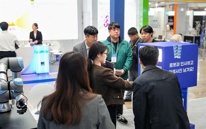 [진주=뉴시스] 로봇전시 참가자가 한국산업기술시험원(KTL) 로봇 악수 포토부스 이벤트에 참여하고 있다. (사진=KTL 제공) 2025.11.07. photo@newsis.com *재판매 및 DB 금지