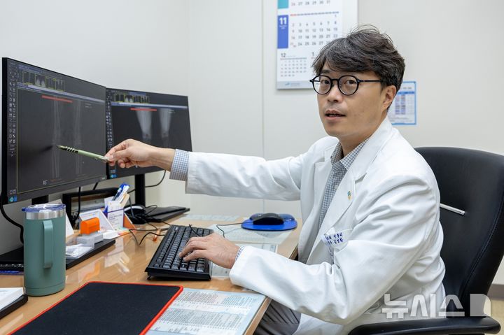 [서울=뉴시스] 김성환 중앙대병원 정형외과 교수가 코넥티브 인공지능 관절염 판독 솔루션 '코네보 코아(CONNEVO KOA)'를 활용해 환자의 무릎 관절염의 진행 상태를 설명하고 있다. (사진= 중앙대병원 제공)