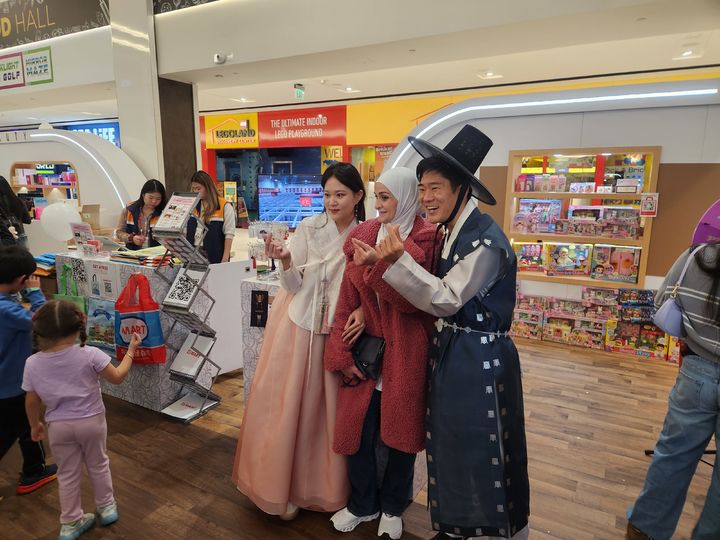 [뉴저지=뉴시스] 지난 7일(현지시간) 미국 뉴저지주 아메리칸드림몰에서 열린 '2025 뉴욕 한류박람회' B2C(기업-소비자 간 거래) 판촉전에 참가한 아트박스 관계자들이 한복을 입고 관람객들과 기념사진을 찍고 있다. 2025.11.09 photo@newsis.com *재판매 및 DB 금지