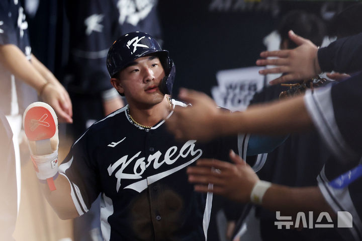 한국 3회초 공격 1사 주자 2, 3루서 문보경의 내야 땅볼 때 3루 주자 안현민이 홈인한 뒤 더그아웃에서 동료들과 하이파이브하고 있다.