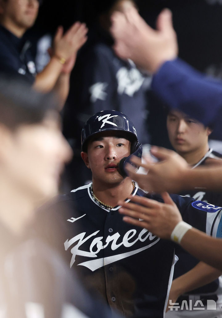 한국 3회초 공격 1사 주자 2, 3루서 문보경의 내야 땅볼 때 3루 주자 안현민이 홈인한 뒤 더그아웃에서 동료들과 하이파이브하고 있다.
