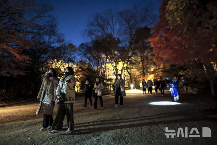[서울=뉴시스] 정병혁 기자 = 10일 서울 종로구 창경궁에서 열린 2025 야간관람 '동궐동락'을 찾은 궁 내부를 걷고 있다. 2025.11.10. jhope@newsis.com