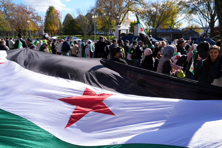 [워싱턴=AP/뉴시스] 전날 시리아에서 미군을 겨냥한 기습 공격으로 미군 2명과 미국인 민간이 1명이 사망한 숨진 사건의 범인은 극단주의 성향으로 해임이 예정돼 있던 시리아 보안군 소속 인물이었다고 월스트리트저널이 14일(현지 시간) 보도했다. 사진은 지난달 10일(현지 시간) 미국 백악관 밖에서 시리아 국적으로 보이는 사람들이 대형 국기를 들고 아메드 알샤라 시리아 대통령을 환영하고 있다. 2025.12.15.