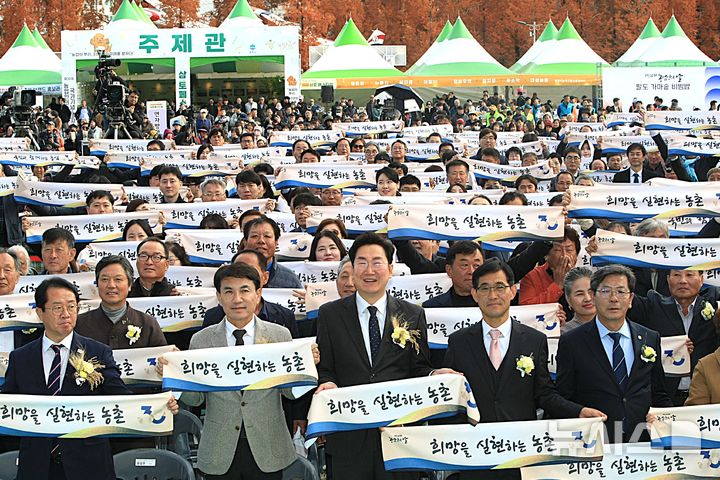[원주=뉴시스] 이덕화 기자 = 11일 '제30회 농업인의 날 국가기념식'이 강원 원주시 댄싱공연장에서 열린 가운데 원강수 원주시장을 비롯한 내빈들이 '희망을 실현하는 농촌' 문구가 새겨진 슬로건을 들고 퍼포먼스를 하고 있다. 2025.11.11. wonder8768@newsis.com