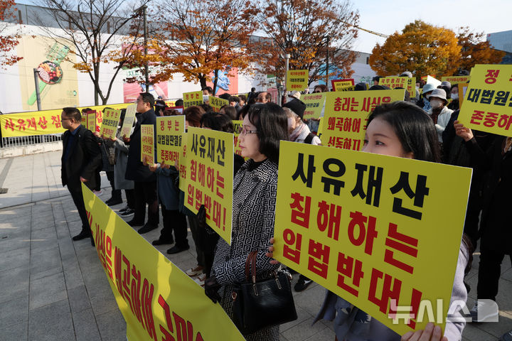 [서울=뉴시스] 조성우 기자 = 세운4구역주민대표회의 관계자들과 토지주들이 11일 오후 서울 종로구 세운상가 앞 광장에서 국가유산청이 유네스코 세계문화유산인 종묘 인근에 초고층 건물을 세우도록 허가하는 서울시 도시 정비 계획에 대해 우려를 표한 것에 대해 반발하며 구호를 외치고 있다. 2025.11.11. xconfind@newsis.com
