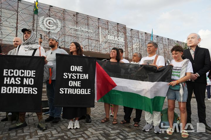 [벨렝(브라질)=AP/뉴시스] 브라질 벨렝에서 열리고 있는 제30차 유엔 기후변화협약 당사국총회(COP30) 행사장 밖에서 11일 친 팔레스타인 활동가들이 시위를 벌이고 있다. 2025.11.12.