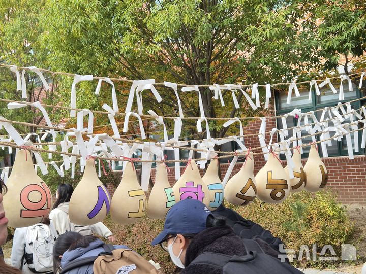 [울산=뉴시스] 구미현 기자 = 2026학년도 대학수학능력시험 예비소집일인 12일 울산 중구 약사고에서 고3 수험생들이 후배들이 준비한 응원을 받으며 하교를 하고 있다. 2025.11.12. gorgeouskoo@newsis.com