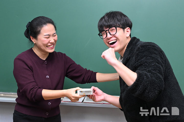 [서울=뉴시스] 정병혁 기자 = 2026학년도 대학수학능력시험을 하루 앞둔 12일 오전 서울 종로구 중앙고등학교에서 고3 수험생이 담임선생님으로부터 수험표와 응원 선물을 받고 있다.(공동취재) 2025.11.12. photo@newsis.com