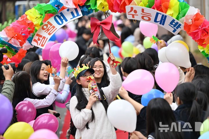 [광주=뉴시스] 이영주 기자 = 2026학년도 대학수학능력시험을 하루 앞둔 12일 오전 광주 남구 설월여고에서 고3 수험생들이 후배들의 응원을 받으며 '수능 대박 종'을 치고 있다. 2025.11.12. leeyj2578@newsis.com
