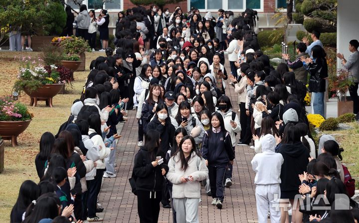  [부산=뉴시스] 하경민 기자 = 2026학년도 대학수학능력시험을 하루 앞둔 12일 부산 사상구 주례여고에서 고3 수험생들이 수험표를 받은 뒤 후배, 교사 등의 응원을 받으며 학교를 나서고 있다. 올해 부산지역 수능 지원자는 2만8883명이며, 오는 13일 62개 고사장에서 시험에 응시한다. 2025.11.12. yulnetphoto@newsis.com