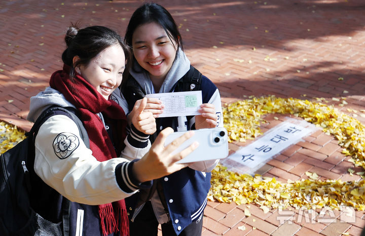 [서울=뉴시스] 최진석 기자 = 2026학년도 대학수학능력시험을 하루 앞두고 예비소집이 실시된 12일 서울 중구 이화여고에서 이화여고 수험생들이 수능대박을 기원하며 수험표를 들고 셀카를 찍고 있다. 사진은 기사 내용과 무관. 2025.11.12. myjs@newsis.com