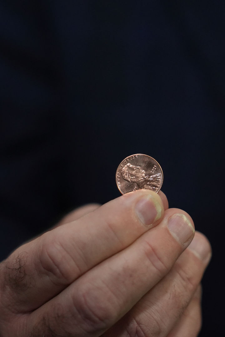 [필라델피아=AP/뉴시스] 브랜던 비치 미 연방 재무관이 12일(현지 시간) 펜실베이니아주 필라델피아 조폐국에서 주조된 마지막 1센트(페니) 동전 중 하나를 들고 있다. 도널드 트럼프 대통령은 지난 2월 1센트 동전 생산 비용이 액면가보다 크다며 생산 중단을 지시했다. 이로써 1센트 동전은 232년 만에 그 운명을 다하게 됐다. 2025.11.13.