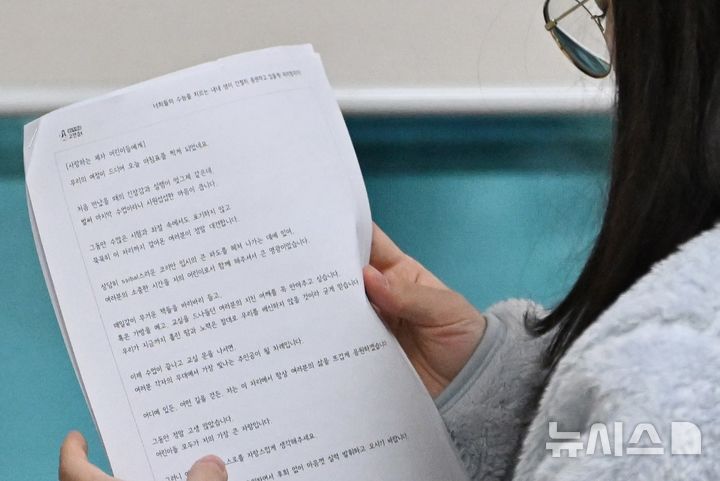 [광주=뉴시스] 이영주 기자 = 2026학년도 대학수학능력시험이 치러지는 13일 오전 광주 북구 광주시교육청 26지구 제28시험장(국제고등학교)에서 한 수험생이 교사의 편지를 읽고 있다. 2025.11.13. leeyj2578@newsis.com