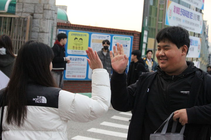 [천안=뉴시스] 최영민 기자 = 13일 대학수학능력시험이 치러진 충남 천안시 중앙고등학교 앞에서 한 수험생과 교사가 하이파이브를 하고 있다. 2025.11.13. ymchoi@newsis.com *재판매 및 DB 금지