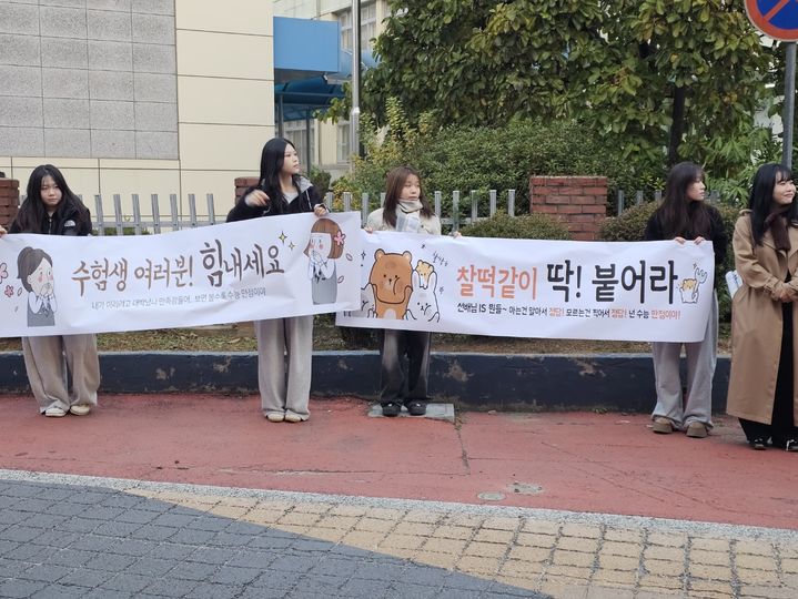 [서산=뉴시스] 김덕진 기자 = 13일 충남교육청 2026학년도 대학수학능력시험 63지구 제2시험장인 서산여고를 찾은 후배 학생들이 정문 앞 거리에서 선배들의 수능을 응원하는 현수막을 들고 서 있다. 2025.11.13. spark@newsis.com *재판매 및 DB 금지