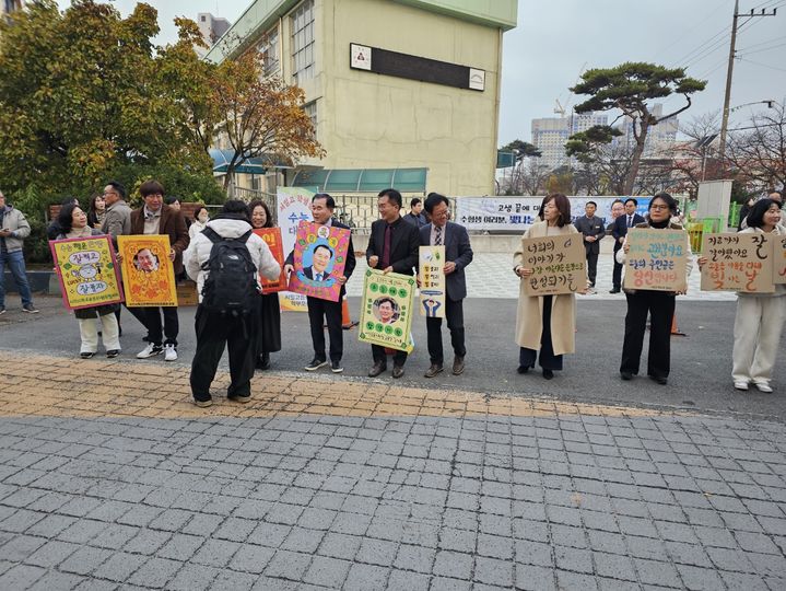 [서산=뉴시스] 김덕진 기자 = 13일 충남교육청 2026학년도 대학수학능력시험 63지구 제2시험장인 서산여고를 찾은 김지철(분홍색 줄무늬 손팻말) 충남교육감 등이 수험생 응원 손팻말을 들고 자신들의 앞을 지나는 수험생들을 응원하고 있다. 2025.11.13. spark@newsis.com *재판매 및 DB 금지